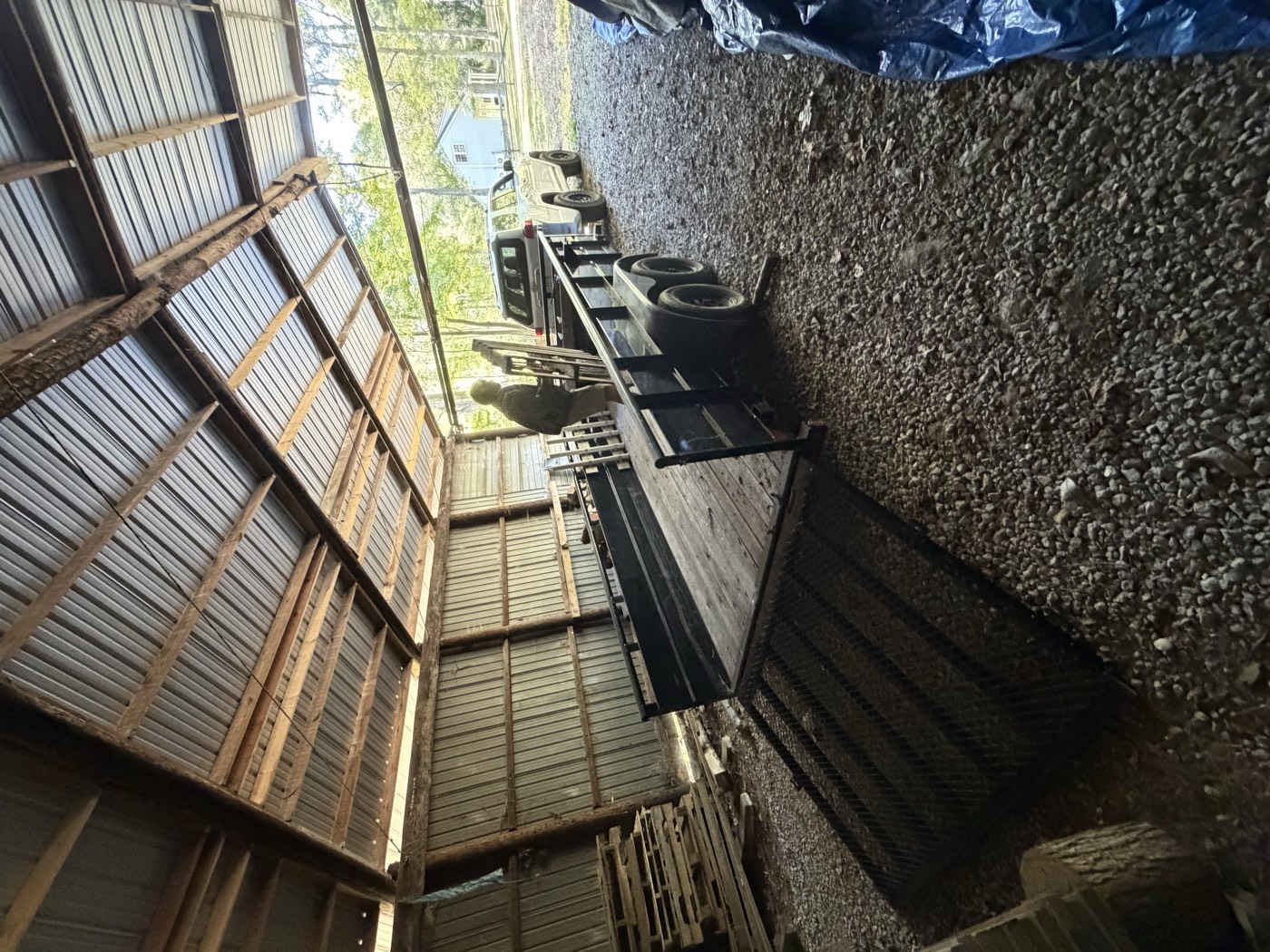 Utility trailer backed into a barn with the ramp gate lowered