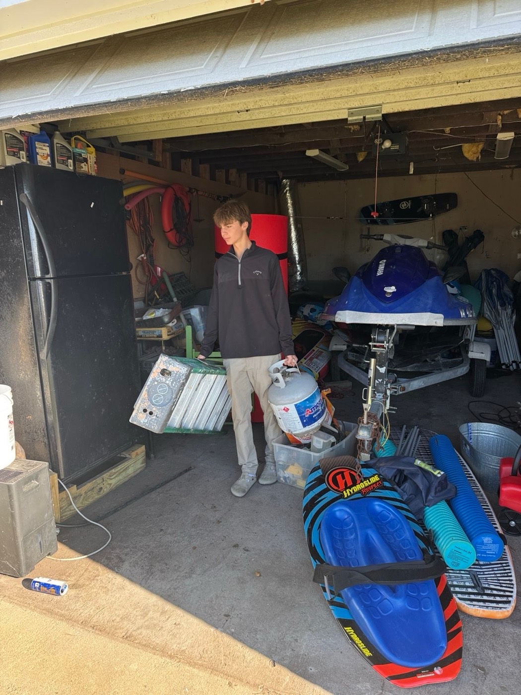 Crew member carrying boxes and clutter out of the garage