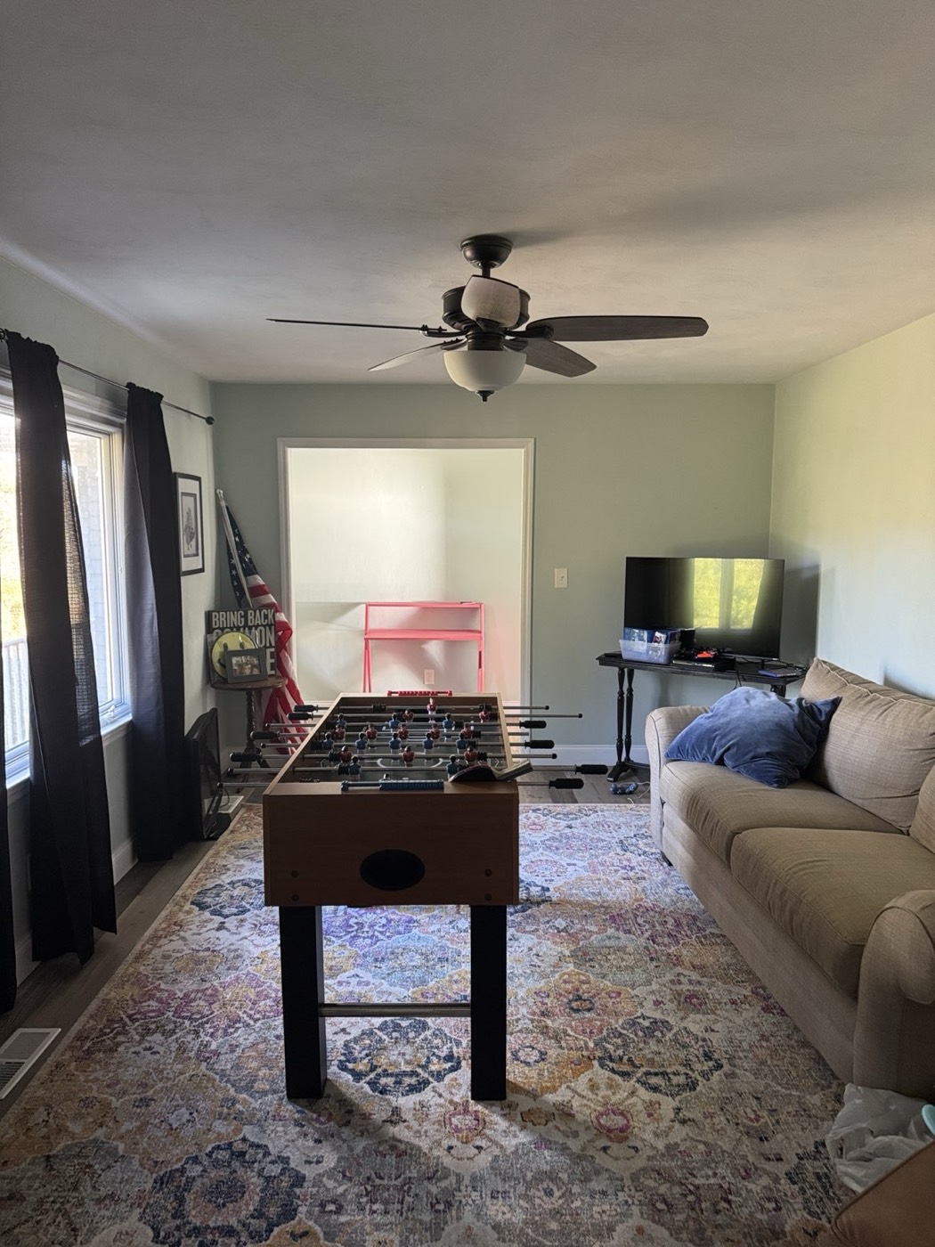 Living room before: foosball table, couch and clutter
