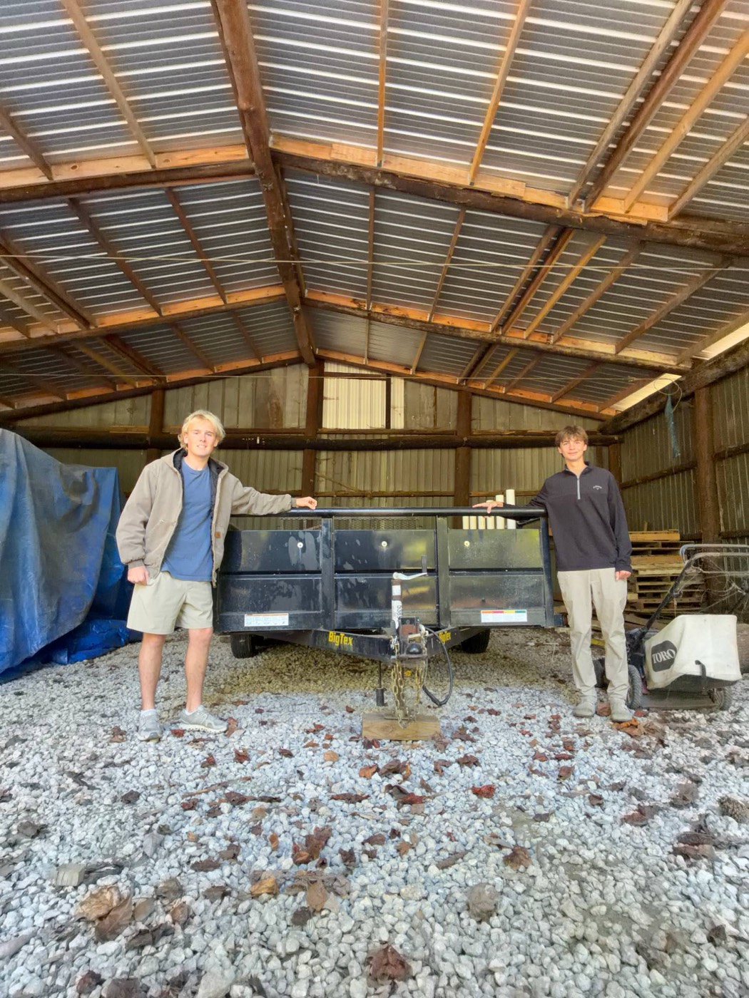 The two-person crew standing beside their Big Tex trailer in the barn